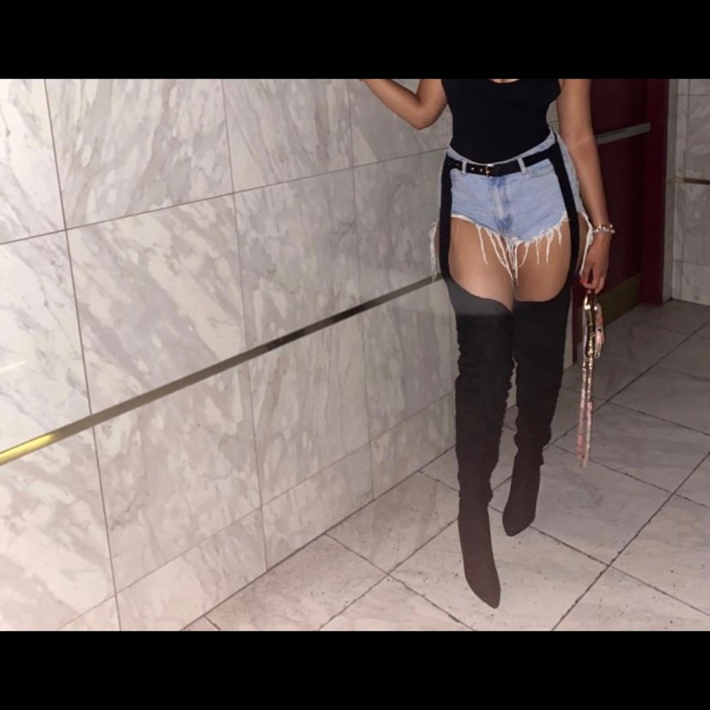 Thigh high black suede boots with belt.
